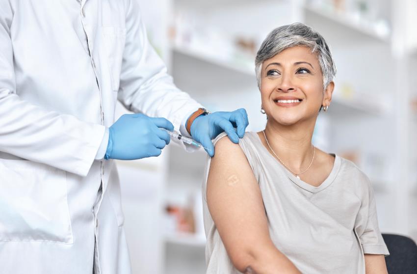 Woman getting a vaccination in the arm and smiling