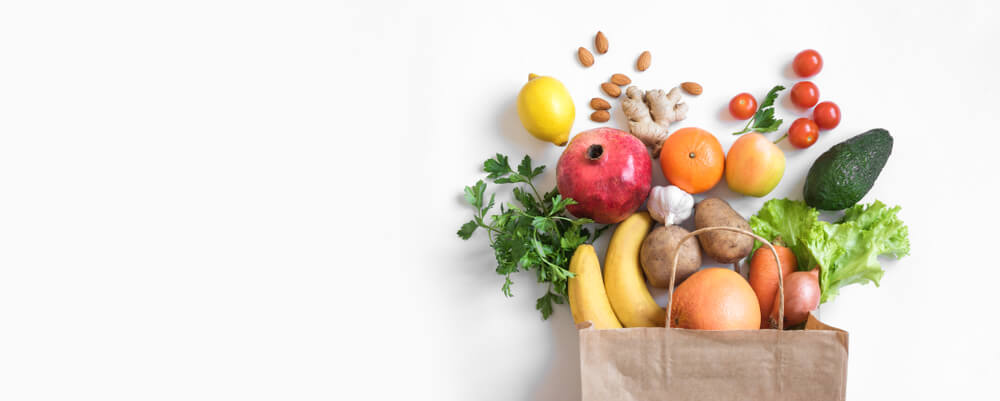 Healthy vegetarian food in paper bag vegetables and fruits on white, copy space, banner. 