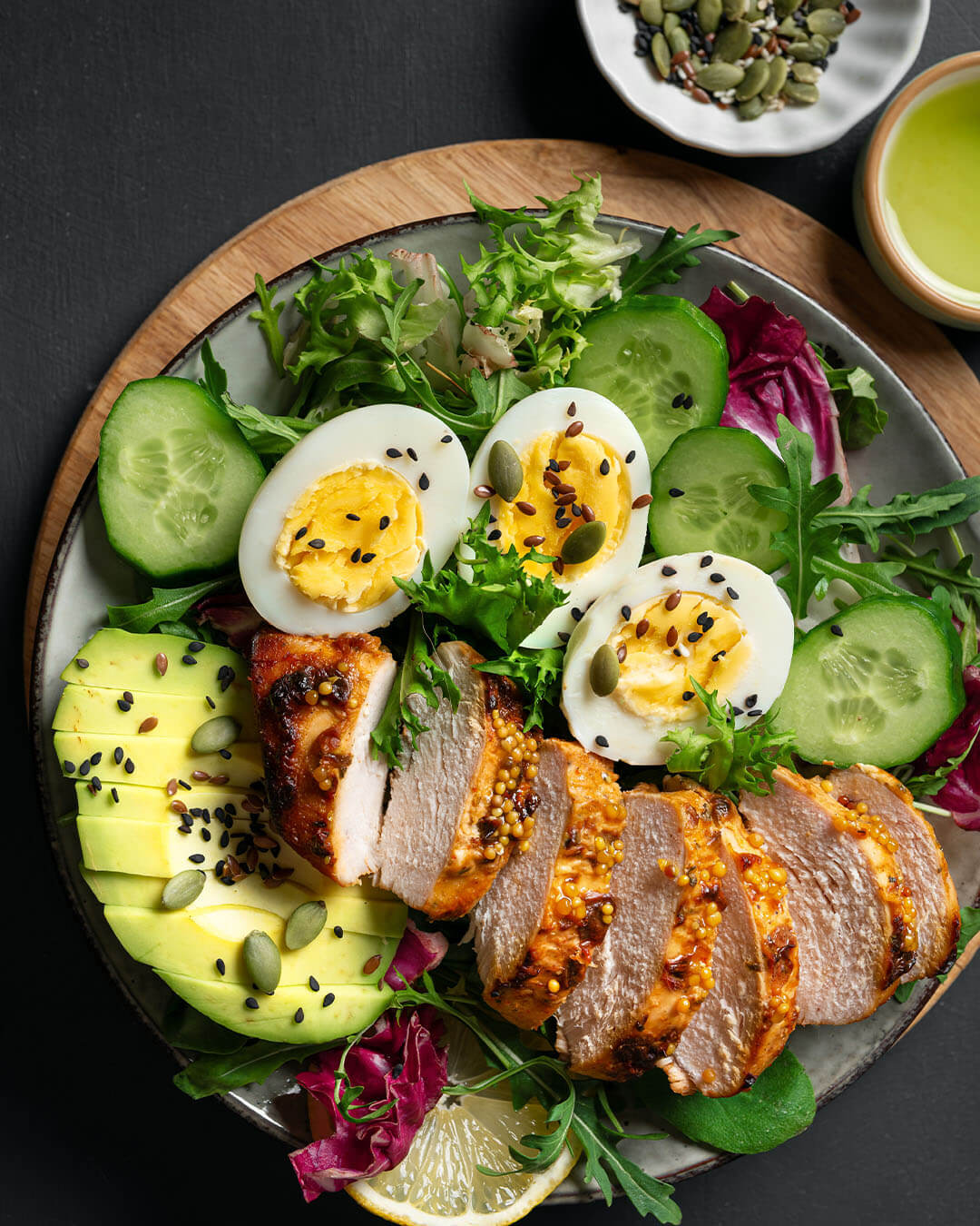 High protein lunch bowl with chicken, eggs, avocado and green vegetables. Healthy low carb eating concept template. Organic salad detailed close up.
