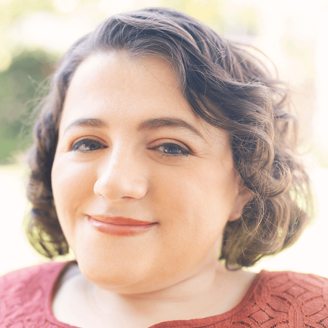 Headshot of Kristen Lopez, writer, editor, and disability advocate, smiling at the camera.