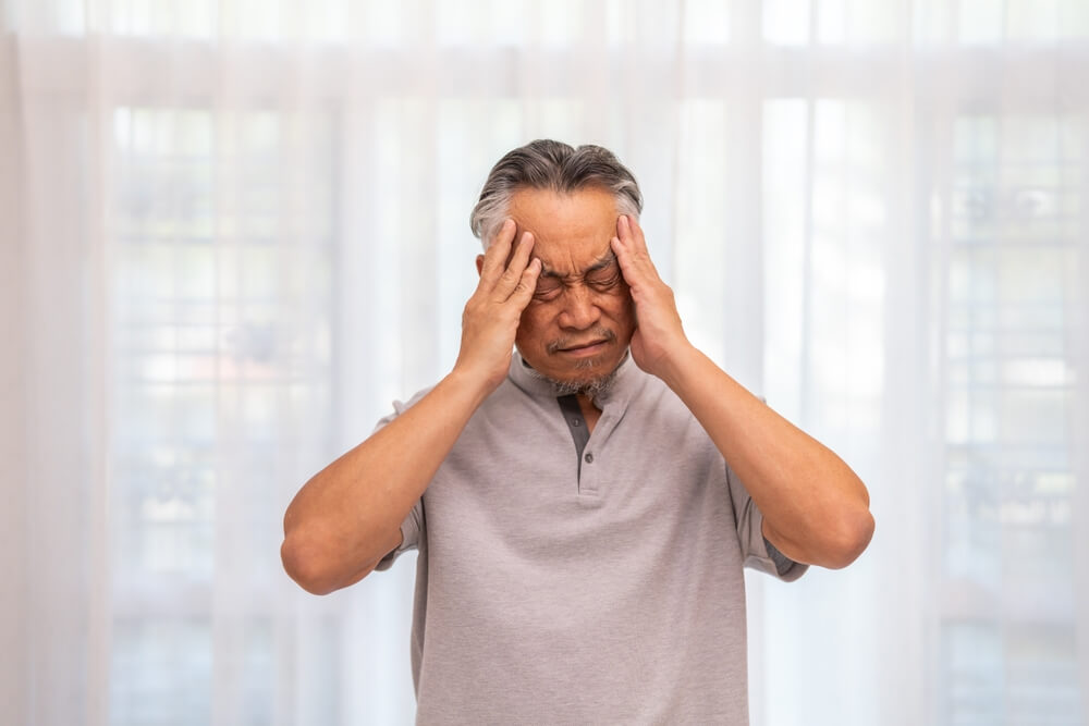 Sick unhappy senior elderly man touching head serious depressed feeling headache thinking of problem