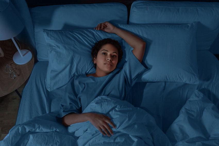 Woman lying in bed unable to sleep