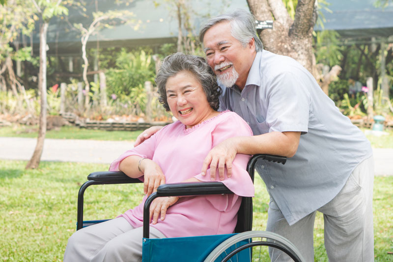 Man pushing woman in wheelchair